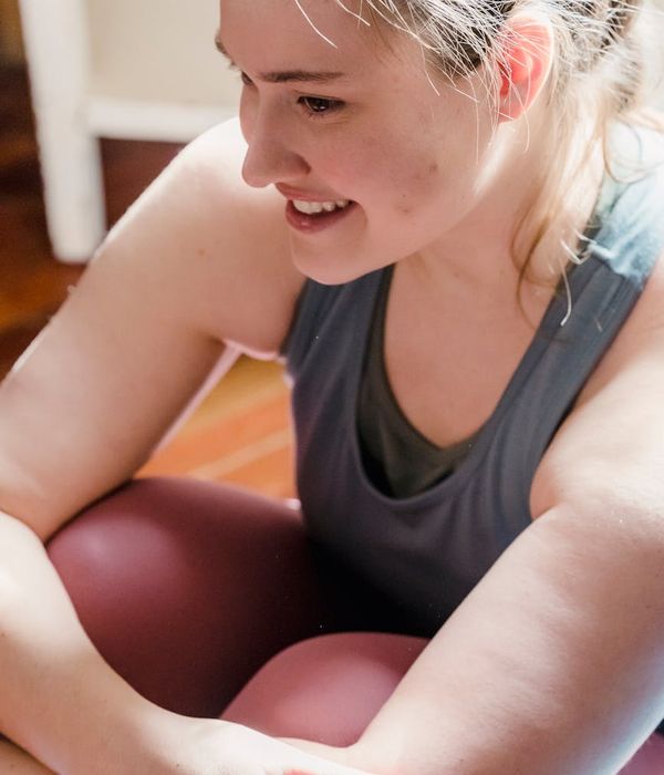 Woman in comfortable sportswear smiling during a light exercise.